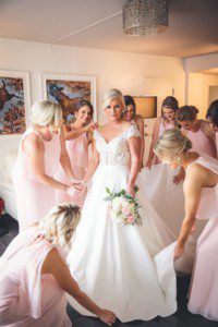 Bridesmaids helping bride get ready